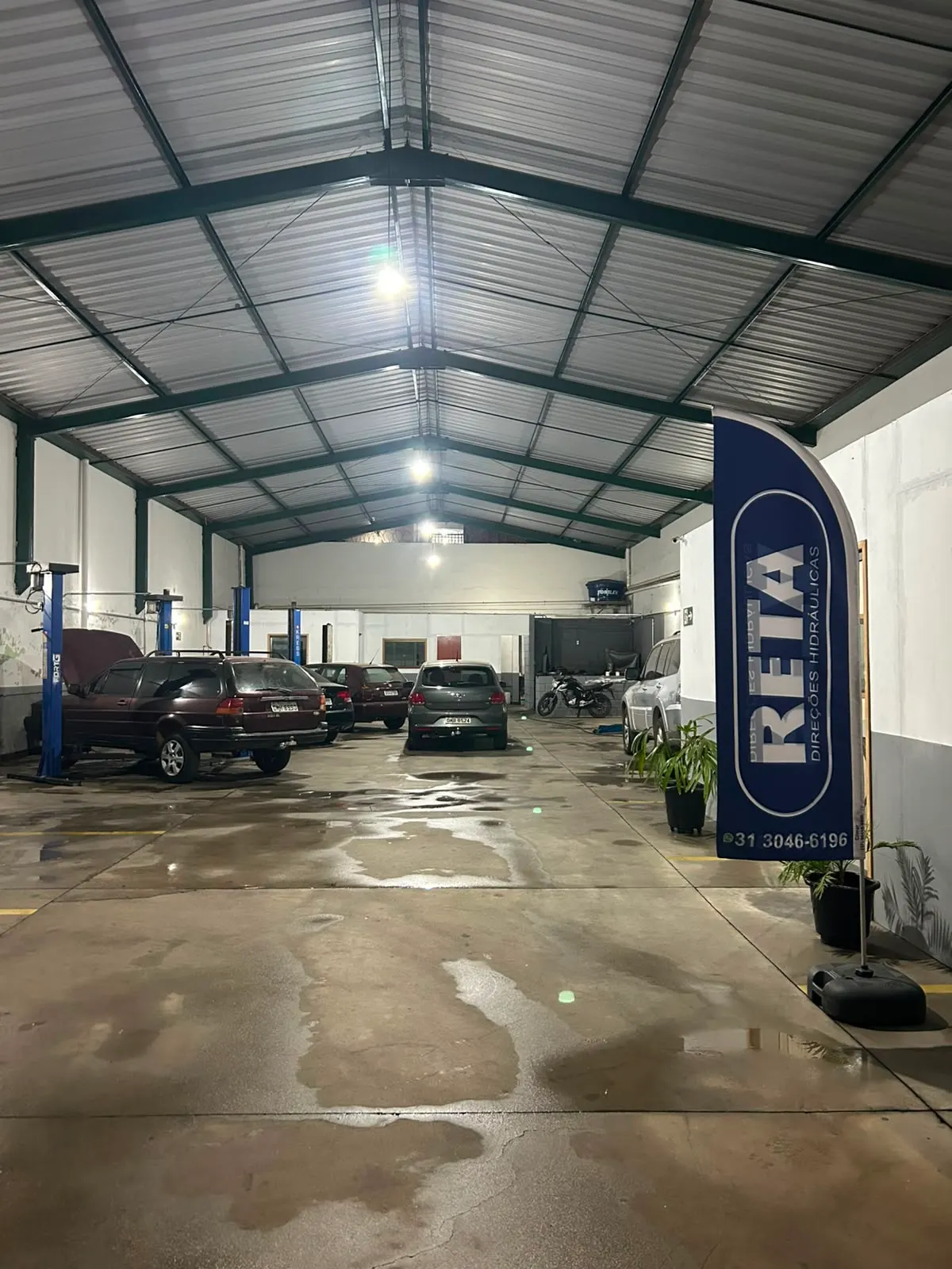 Oficina da Reta Direções Hidráulicas com veículos em serviço e bandeira da marca
